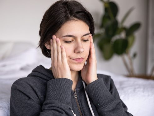 Person experiencing jaw discomfort associated with teeth grinding